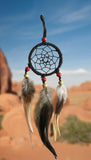 2-1/2" diameter ring wrapped in black leather and adorned with black leather straps and brown &amp; white feathers.