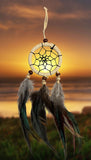 2-1/2" diameter ring wrapped in authentic creme leather with cream leather straps and brown & white feathers and brown and beige wooden beads on a golden background.